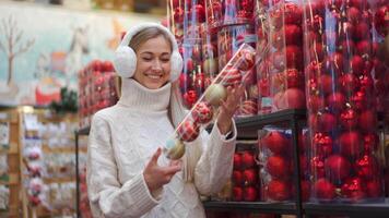 un mujer en un suéter y orejeras mirando a Navidad accesorios video