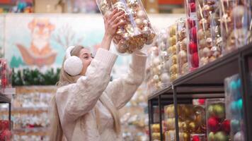 a woman in a sweater and earmuffs looking at Christmas accessories video