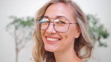 retrato un mujer con lentes es sonriente y mirando a el cámara video