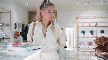 a woman is looking at jewellery in a department store video