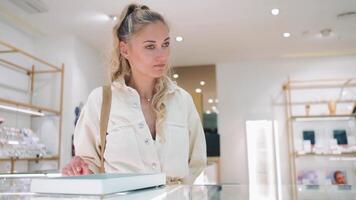 un mujer es mirando a joyería en un Departamento Tienda video