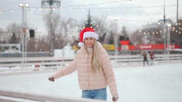 une femme dans une chapeau patinage sur une patinoire video