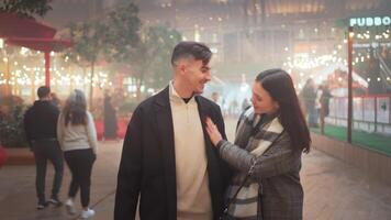 Happy romantic couple enjoying walk on city street during Christmas night video