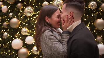 Happy romantic couple rubbing noses and kissing on illuminated street. video