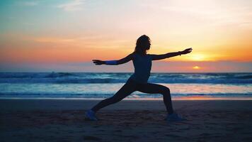 uma mulher fazendo ioga em a de praia às pôr do sol video