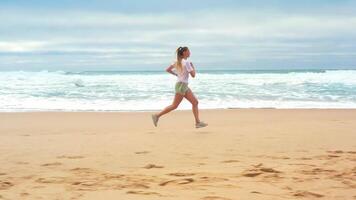 Drone aerial footage slim blonde woman running ocean beach. video