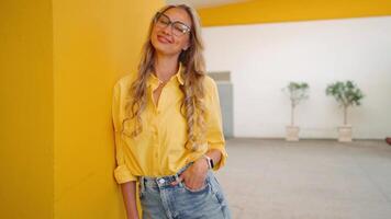 a woman with glasses and a yellow background video