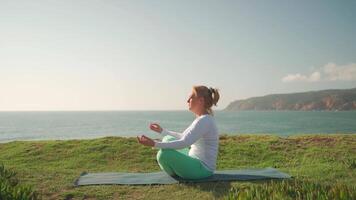 Sénior femme pratiquant yoga exercice sur le plage. video