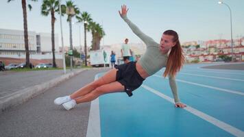 sportig kvinna på löpning Spår håller på med knäböj övningar. video