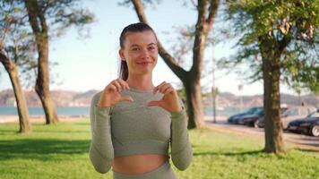 Young adult fitness woman exercising outdoor on green grass. video