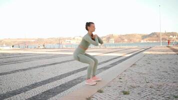 Fitness Frau im Sport tragen tun Ausfallschritte auf Schritt, und Dehnen Beine auf Sommer- Park in der Nähe von Strand. video
