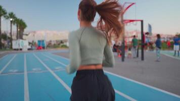 deportivo mujer en corriendo pista haciendo sentadillas ejercicios. video