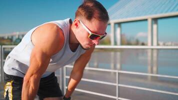 masculino corredor corrida em ponte ensolarado dia. atleta fazendo cardio treinamento. video