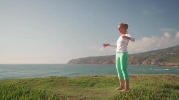 mayor mujer practicando yoga ejercicio en el playa. video