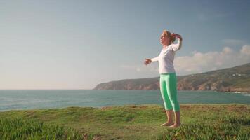 Senior woman practicing yoga exercise on the beach. video