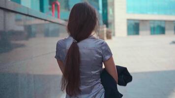 a woman with long hair walking down the street video