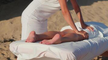 kvinna njuter professionell spa hand massage liggande på särskild tabell på strand under semester. massage terapeut ger avkopplande massage klientens vapen och axlar video