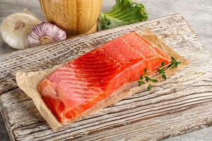 Raw salmon fillet over board photo