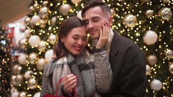 glücklich jung Paar im modisch Kleider reden während Gehen auf Fußweg auf Weihnachten Nacht. video