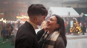 Happy romantic couple rubbing noses and kissing on illuminated street. video