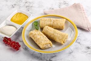 Homemade stuffed pancakes with honey and cream sour photo