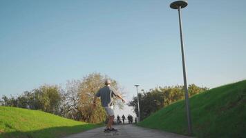volwassen mannetje persoon rijden skateboard in stad park zomer dag. video