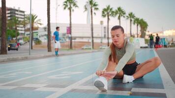 Sporty woman on running track doing squats exercises. video