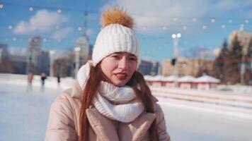 ung leende kvinna is skridskoåkning inuti på is rink. video