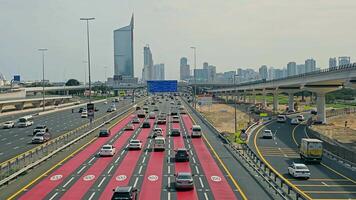 uae, dubai - förenad arab emirates 01 april 2024 dubai motorväg och metro i dagsljus, fågelöga se av trafik strömmande på en dubai motorväg med de metro linje och stad horisont i de bakgrund. video