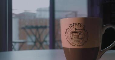 un' caffè seduta su un' tavolo mentre è pioggia al di fuori video