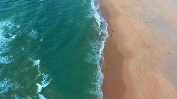 aéreo ver de ola en el playa con arena y turquesa olas video