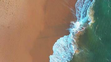 aéreo Visão do onda em a de praia com areia e turquesa ondas video