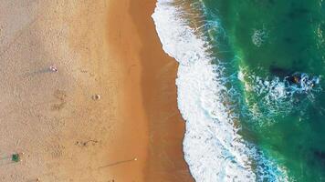 aéreo Visão do onda em a de praia com areia e turquesa ondas video