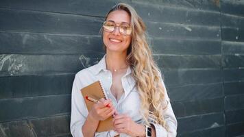 portrait de une femme avec des lunettes souriant vers le caméra video