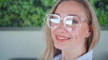 retrato de un mujer con lentes sonriente hacia el cámara video