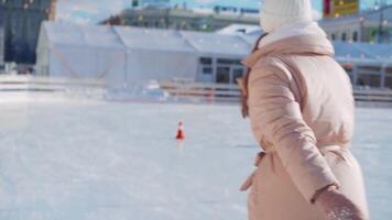 ung leende kvinna is skridskoåkning inuti på is rink. video