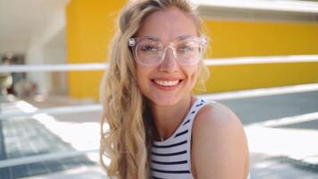 retrato de un mujer con lentes sonriente hacia el cámara video