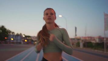 deportivo mujer en corriendo pista haciendo sentadillas ejercicios. video