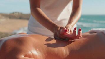 a woman in white dress is doing a back massage on a girl video