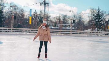 ung leende kvinna is skridskoåkning inuti på is rink. video