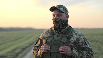 guerre Ukraine Russie. ukrainien militaire soldat dans camouflage à crépuscule, une ukrainien soldat dans camouflage des stands prêt à crépuscule, avec détails de le sien uniforme et équipement. video