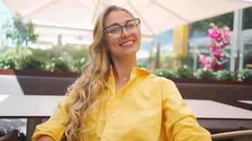 retrato de un mujer con lentes sonriente hacia el cámara video