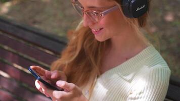 un mujer en lentes utilizando su teléfono video