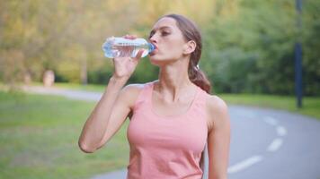 ein Frau ist Trinken Wasser von ein Flasche video