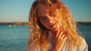 Woman wear white shirt with curly hair standing near the water video