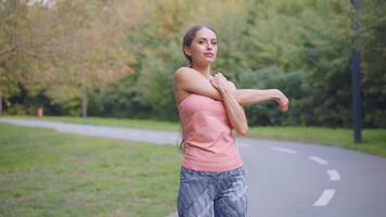 Young athletic woman doing light exercise outdoor video