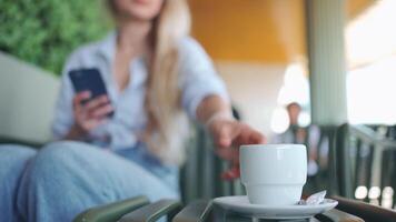 ein Frau ist Sitzung auf ein Bank mit ein Tasse von Kaffee video