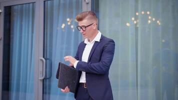 un hombre en un traje y lentes es participación un negro carpeta video