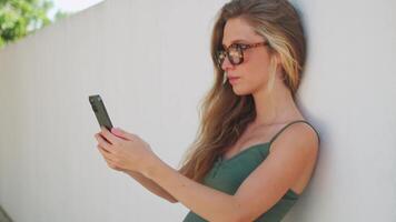 un mujer en lentes utilizando su teléfono video