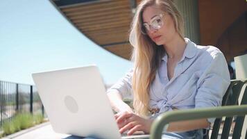 een vrouw in bril zittend terwijl werken Aan haar laptop video